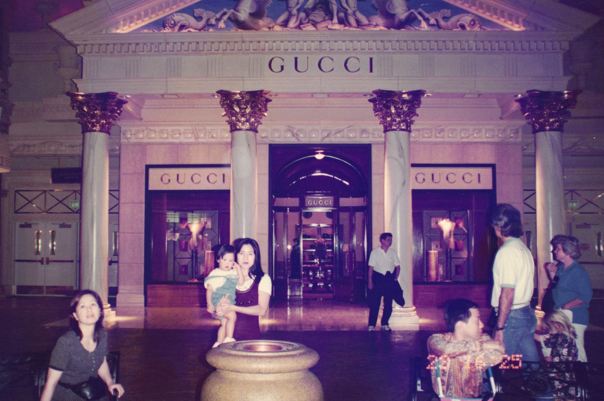 A night interior with grand columns; my mother carries me past a lit storefront