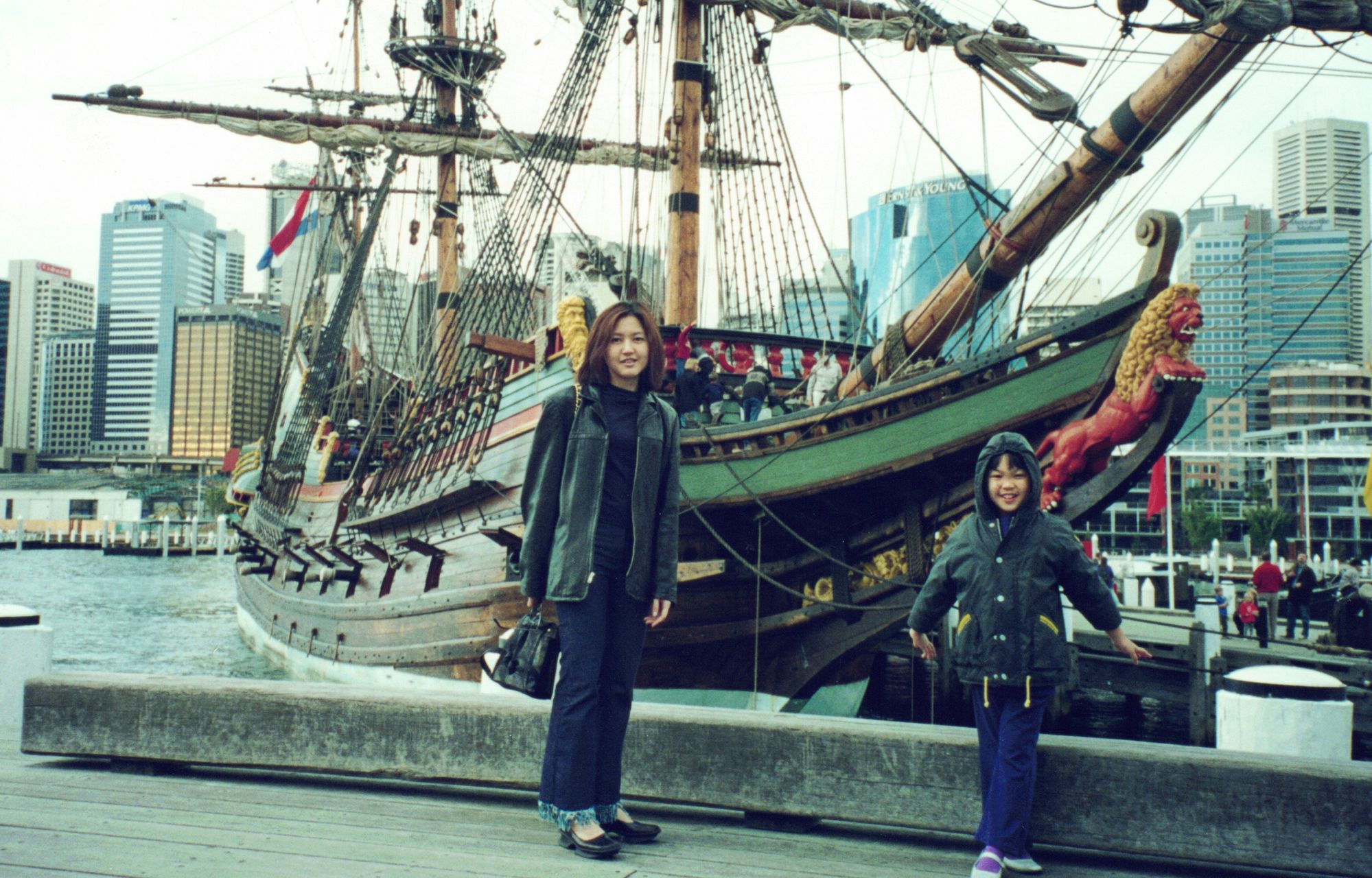 My mother and me before a tall sailing ship in a city harbour