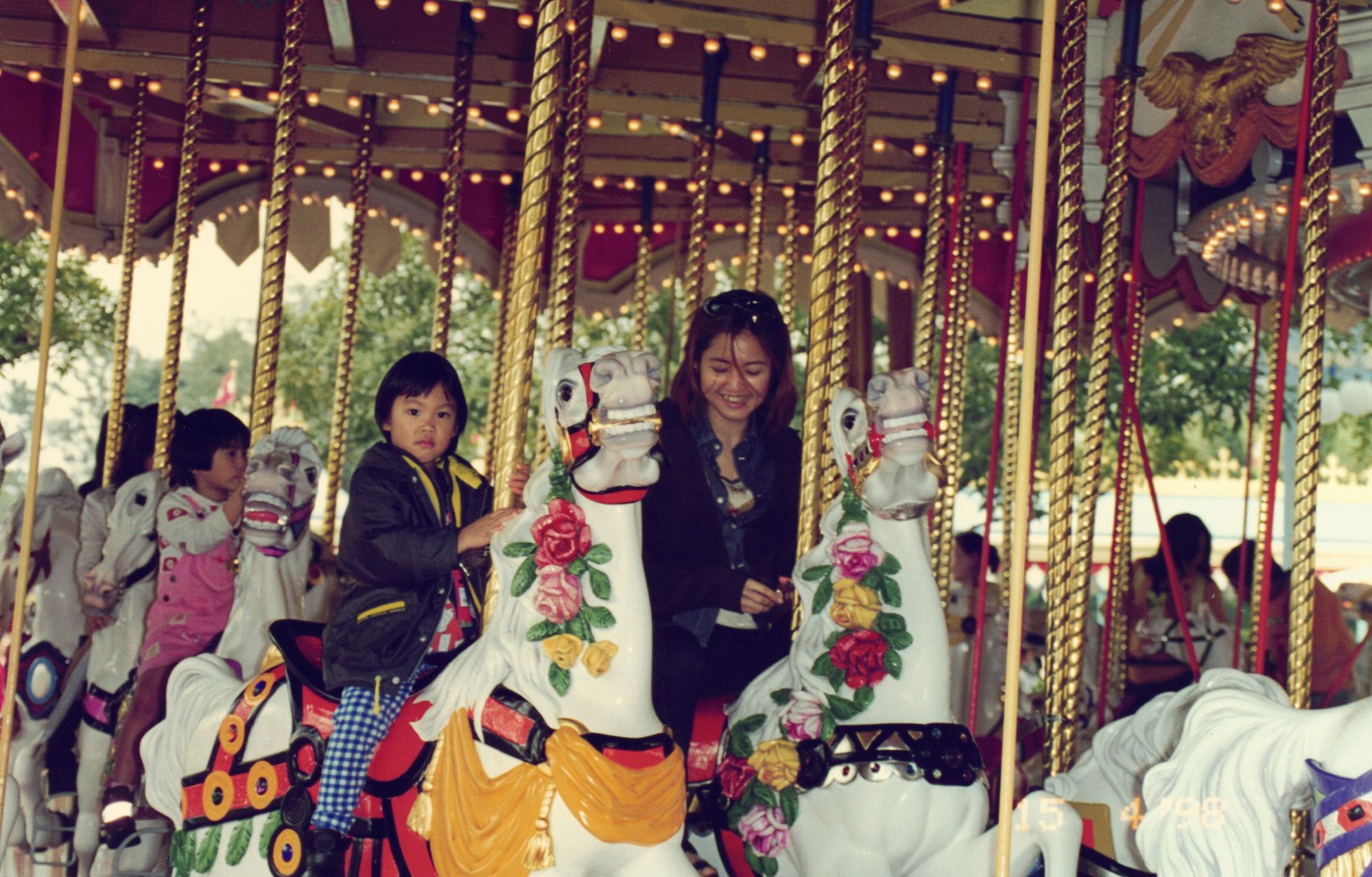 My mother and me riding a carousel