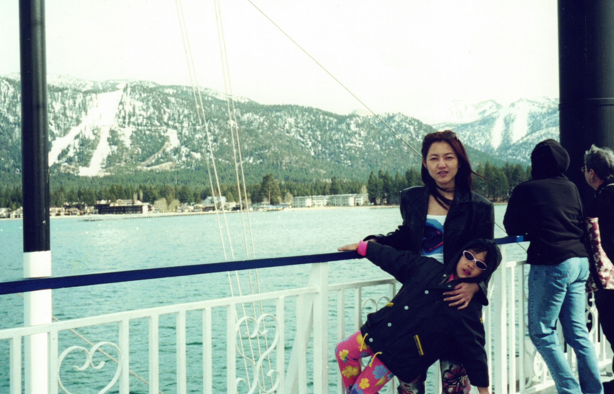 My mother and me on a pier, a lake and snow-covered mountains behind us