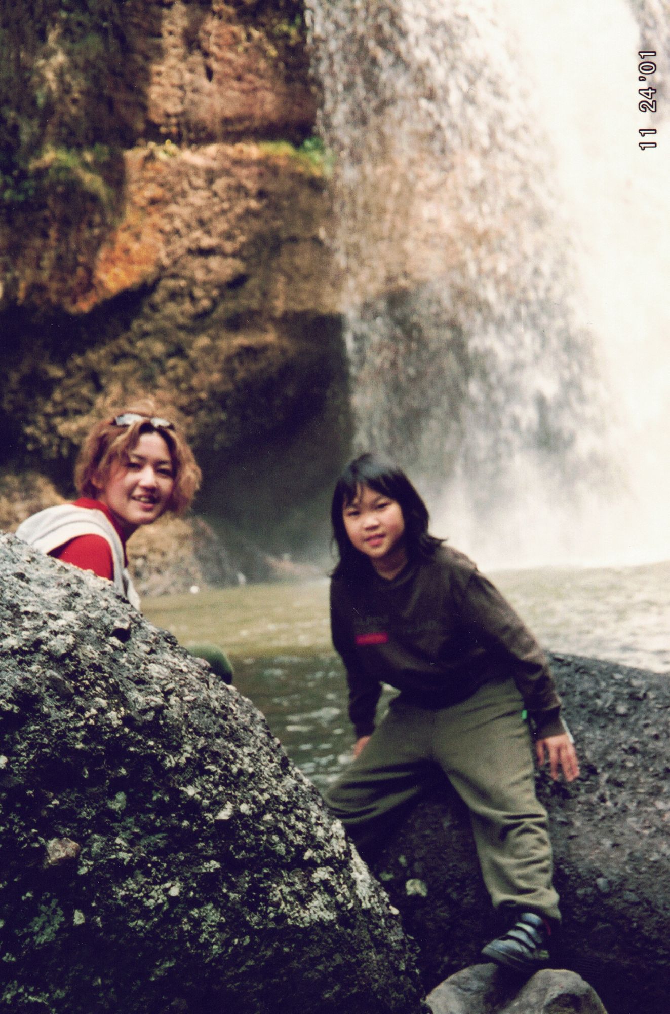My mother and me on the rocks at the foot of a waterfall