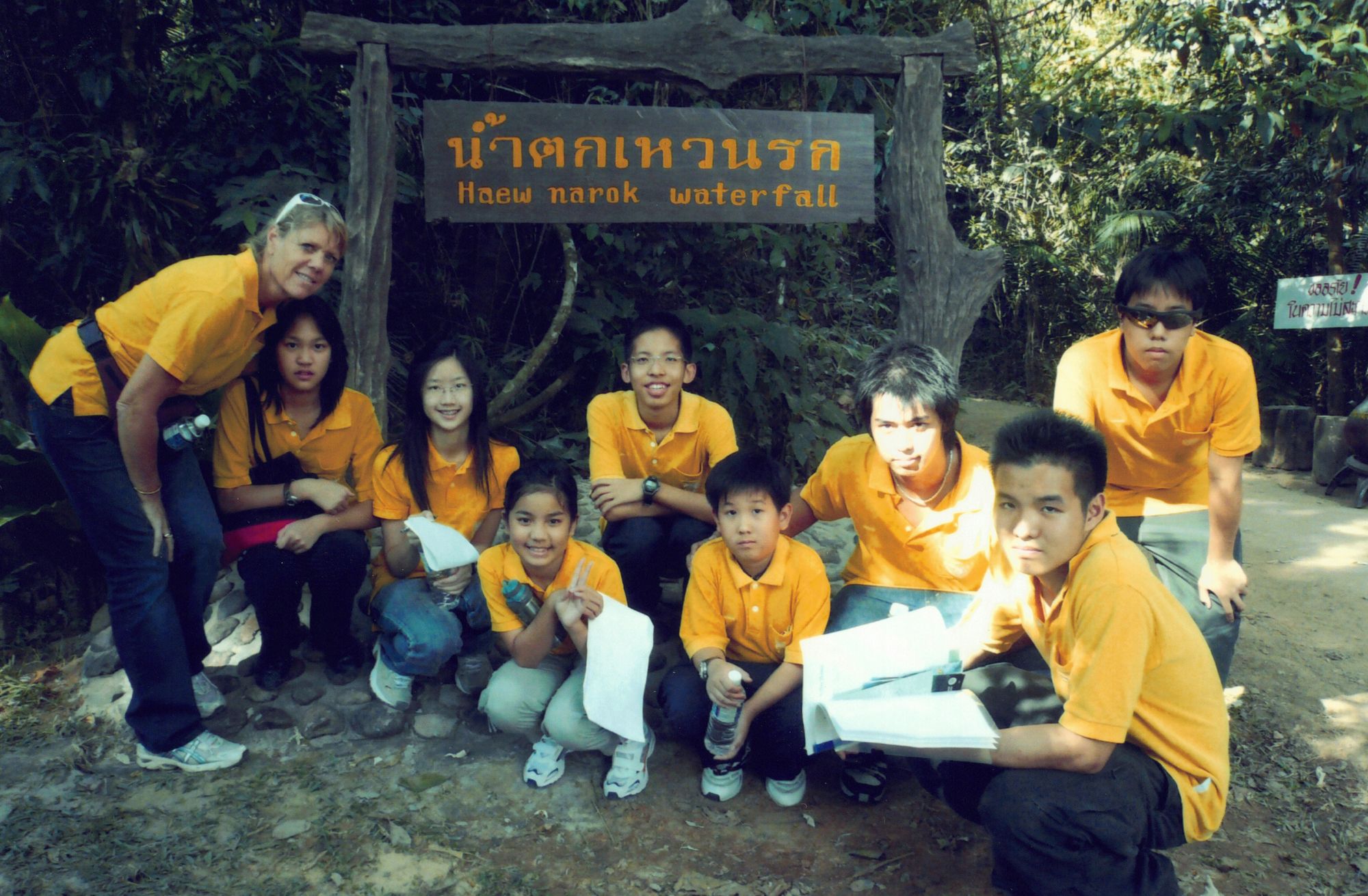 My Keller House group in yellow shirts at the Haew Narok Waterfall sign, on the Year 8 house trip to Nakhon Nayok
