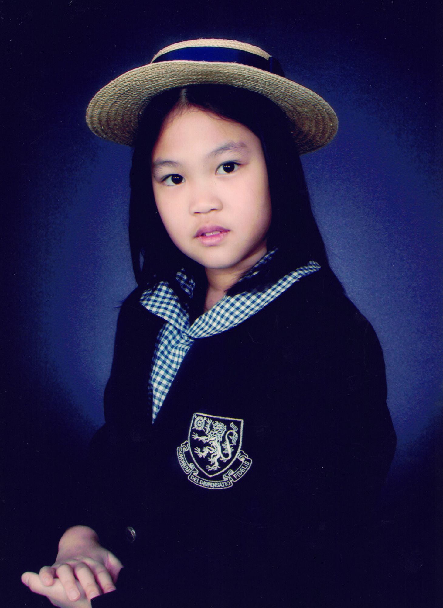 My formal Harrow portrait — dark blazer, gingham collar, boater hat