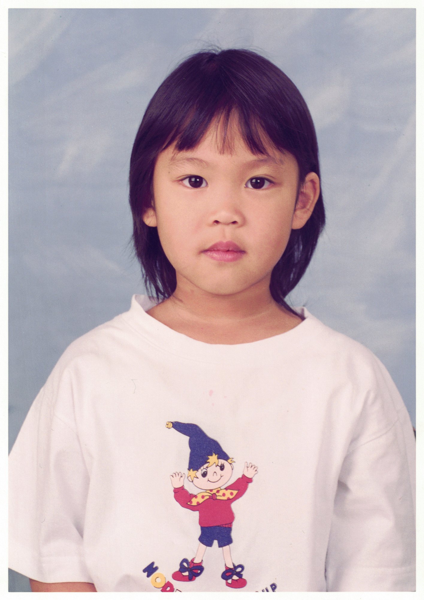 My preschool portrait at Noddy — a white T-shirt with a Noddy print, against a pale studio backdrop